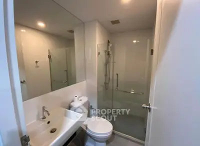 Modern bathroom with glass shower and sleek fixtures in a contemporary apartment.