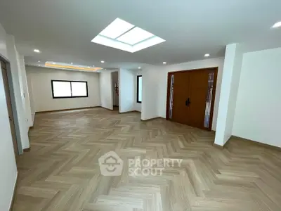 Spacious modern living room with skylight and elegant wooden flooring
