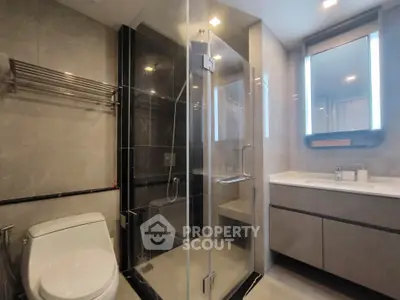 Modern bathroom with glass shower and sleek vanity in luxury apartment