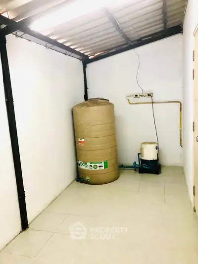Utility room with water tank and pump in a real estate property