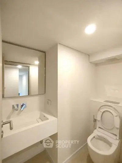 Modern minimalist bathroom with sleek fixtures and bright lighting