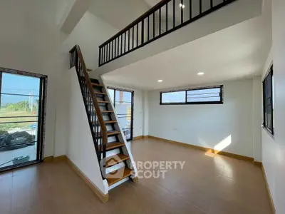 Spacious modern living room with mezzanine and large windows for natural light.