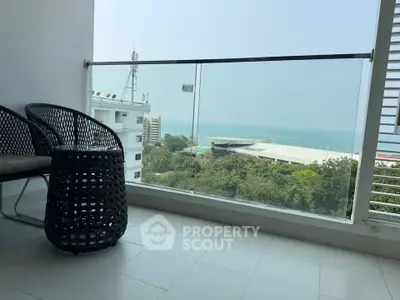 Stunning balcony with ocean view and modern seating, perfect for relaxation.