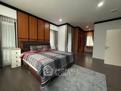 Spacious modern bedroom with stylish decor and ample natural light