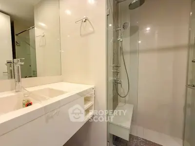 Modern bathroom with glass shower and sleek white vanity