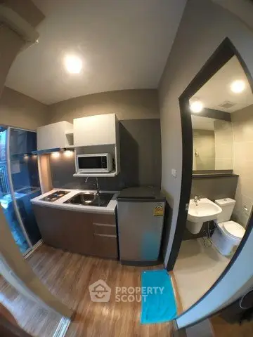 Modern compact kitchen with adjacent bathroom in a cozy apartment
