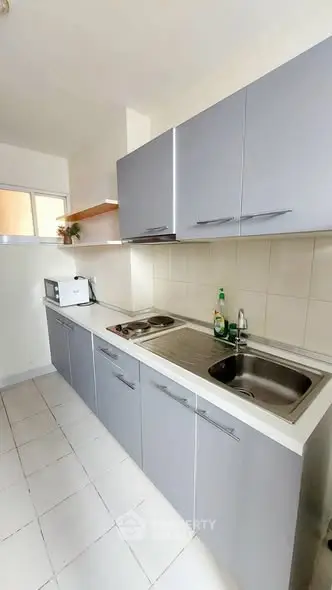 Modern kitchen with sleek cabinetry and built-in appliances in a compact layout.