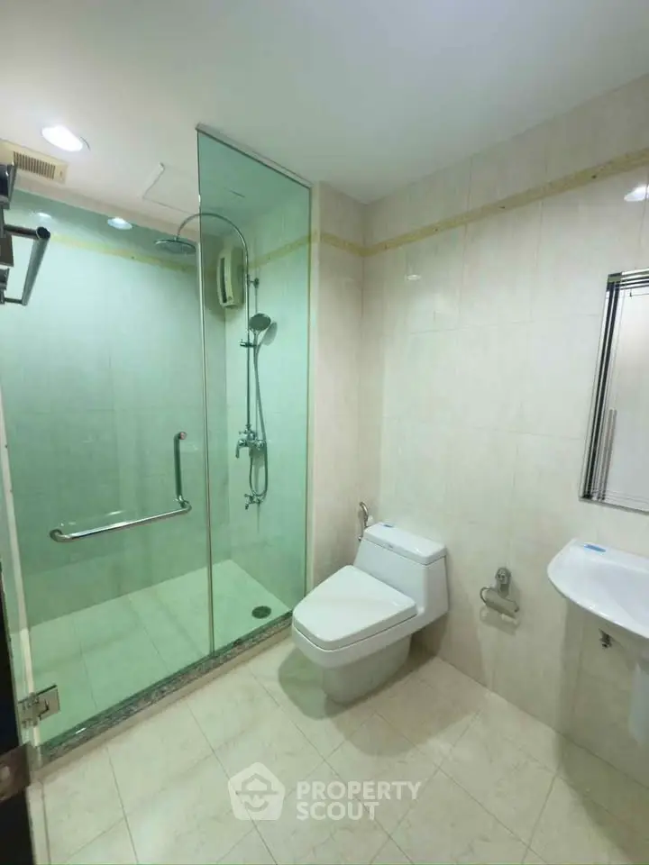 Spacious modern bathroom with glass shower and sleek fixtures in a contemporary home.