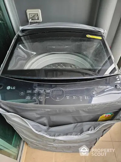 Modern washing machine in sleek laundry area with protective cover