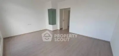 Spacious empty room with wooden flooring and white walls, ideal for customization.