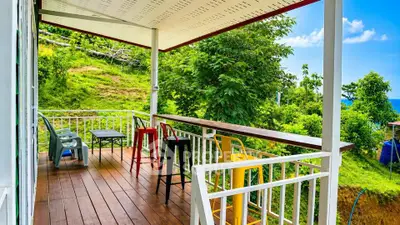 Charming balcony with colorful chairs and lush green view, perfect for relaxation and outdoor enjoyment.