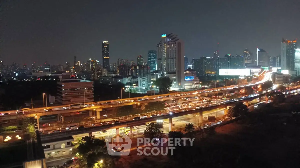 Stunning cityscape view with illuminated skyline and bustling highway at night.