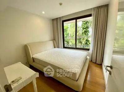 Bright and cozy bedroom with large window and modern furnishings