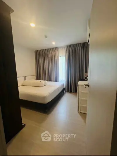 Cozy bedroom with modern decor and natural light, perfect for relaxation and comfort.
