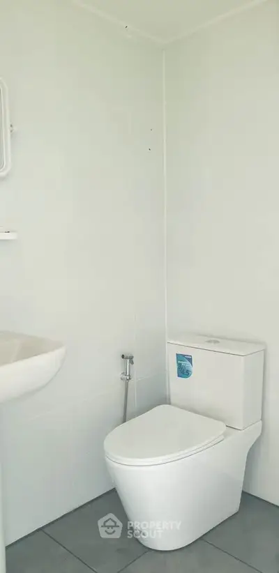 Modern minimalist bathroom with sleek white fixtures and clean design.