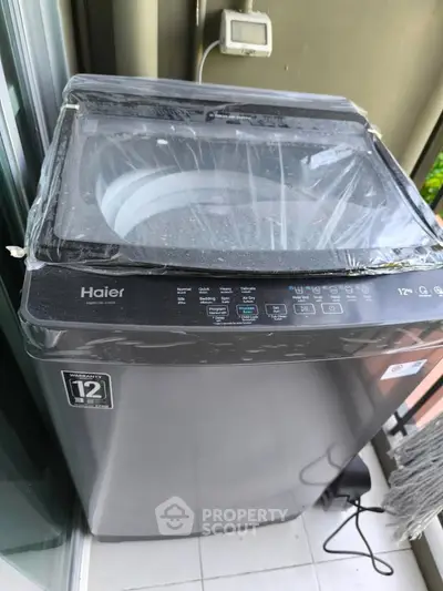 Modern Haier washing machine on a balcony with a sleek design and energy-efficient features.