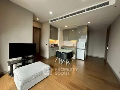 Modern open-plan living room with sleek kitchen and stylish furniture in a contemporary apartment.