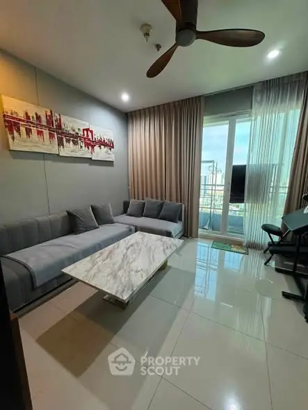 Modern living room with stylish decor and large windows offering natural light and city views.