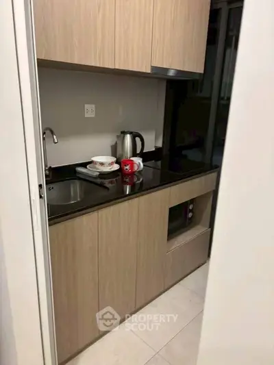 Compact kitchen with wooden cabinets and modern appliances