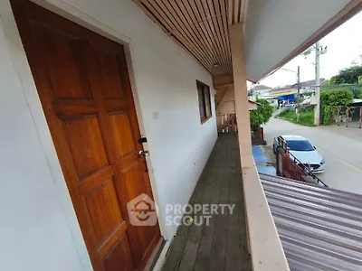 Charming wooden balcony with street view, perfect for relaxing outdoors.
