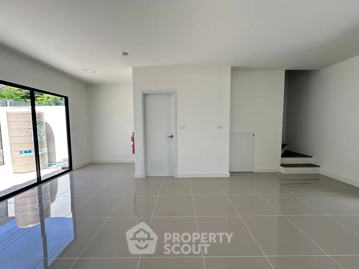 Spacious modern living room with glossy tiled floors and large sliding glass doors.