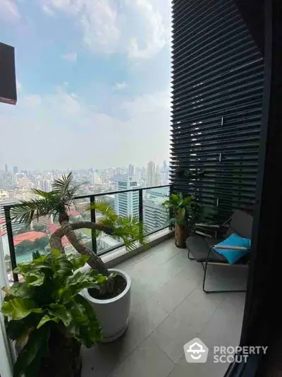 Stunning high-rise balcony with panoramic city views and lush greenery.