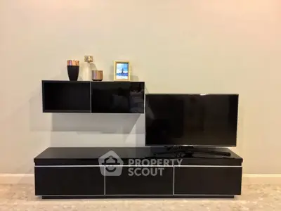 Modern living room with sleek black TV stand and wall-mounted shelves