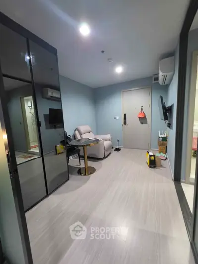 Modern living room with sleek design, featuring a comfortable armchair, wall-mounted TV, and stylish flooring.
