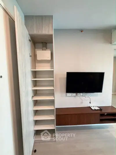 Modern living room with sleek TV setup and built-in shelving unit