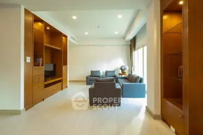 Spacious living room with modern furniture and built-in wooden shelves, ideal for relaxation and entertainment.