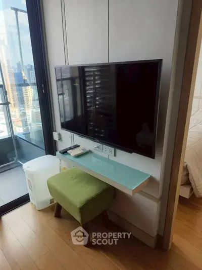 Modern apartment interior with wall-mounted TV and balcony view