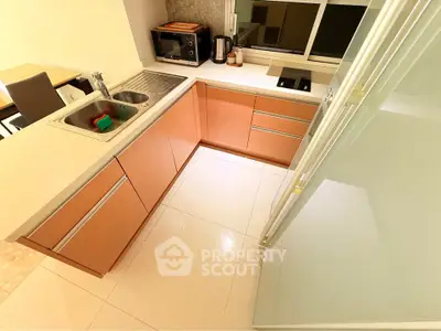 Modern kitchen with sleek cabinetry and built-in appliances in a compact layout.