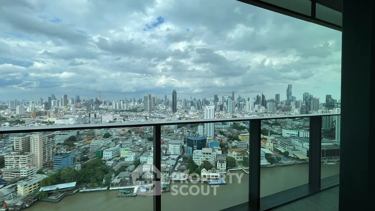 Stunning cityscape view from a high-rise balcony overlooking a river and skyline.