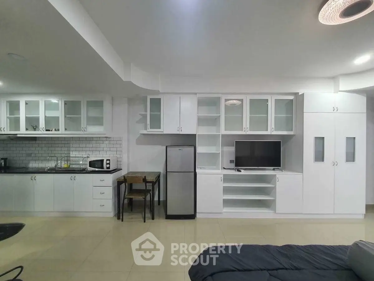 Modern studio apartment with sleek kitchen and cozy living area, perfect for urban living.