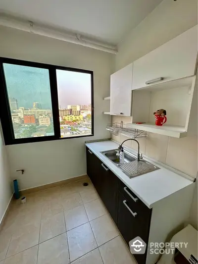 Modern kitchen with city view, sleek cabinetry, and ample natural light.