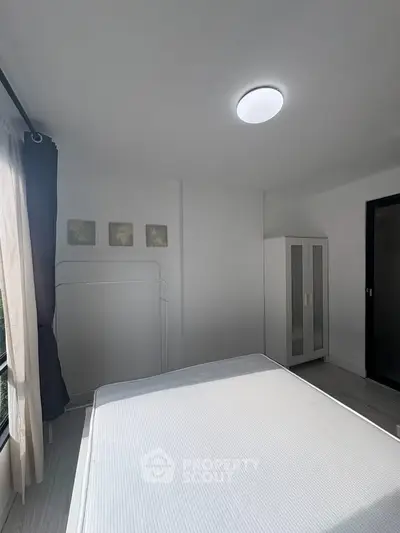 Bright minimalist bedroom with large window and modern wardrobe