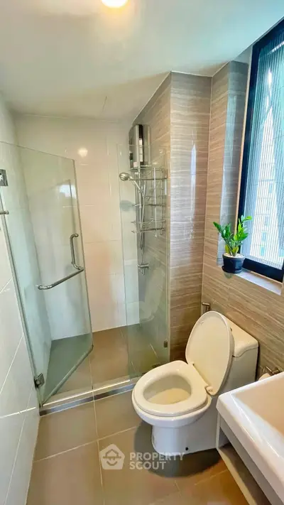Modern bathroom with glass shower and sleek fixtures in a bright, contemporary apartment.