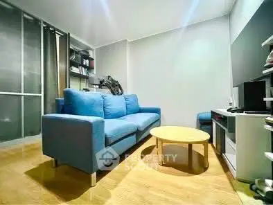 Cozy living room with modern blue sofa and sleek wooden flooring