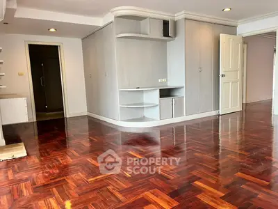 Spacious living room with polished wooden floors and built-in storage