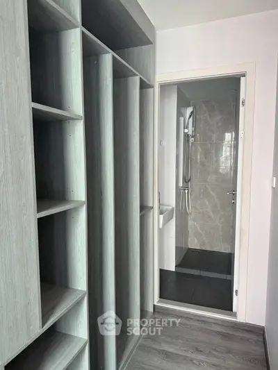 Modern apartment with sleek storage and bathroom, featuring elegant wood finishes and contemporary design.