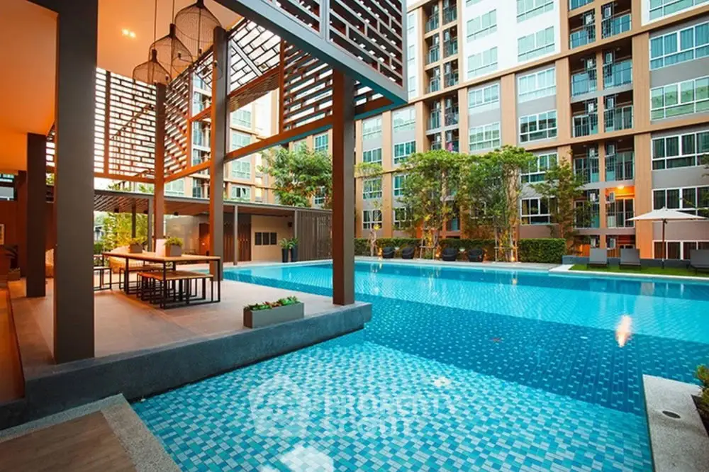 Luxurious apartment complex with stunning pool and modern outdoor seating area.