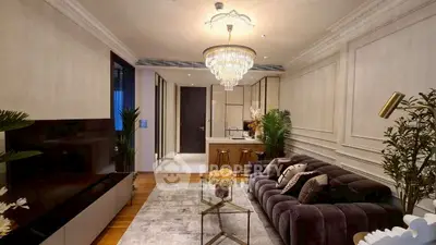 Luxurious living room with elegant chandelier and plush sofa in modern apartment.