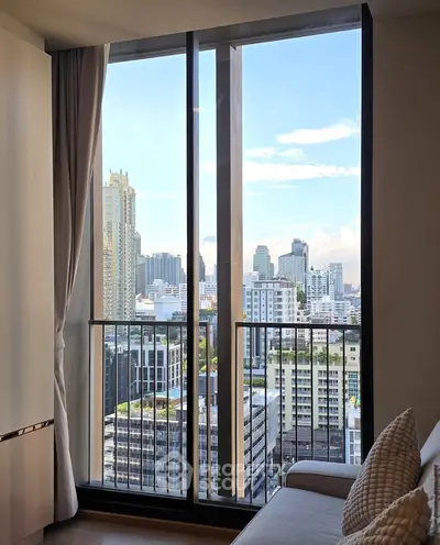 Stunning city view from modern apartment with floor-to-ceiling windows and cozy interior.