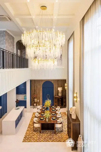 Luxurious double-height dining room with elegant chandelier and modern decor