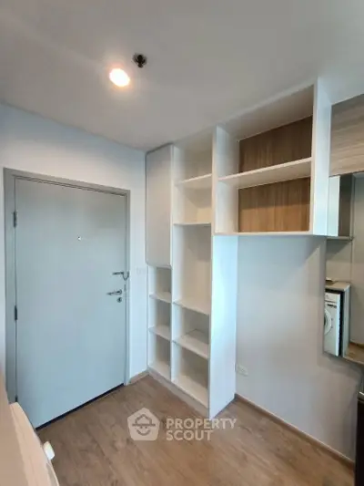 Modern apartment entryway with built-in storage and wooden flooring