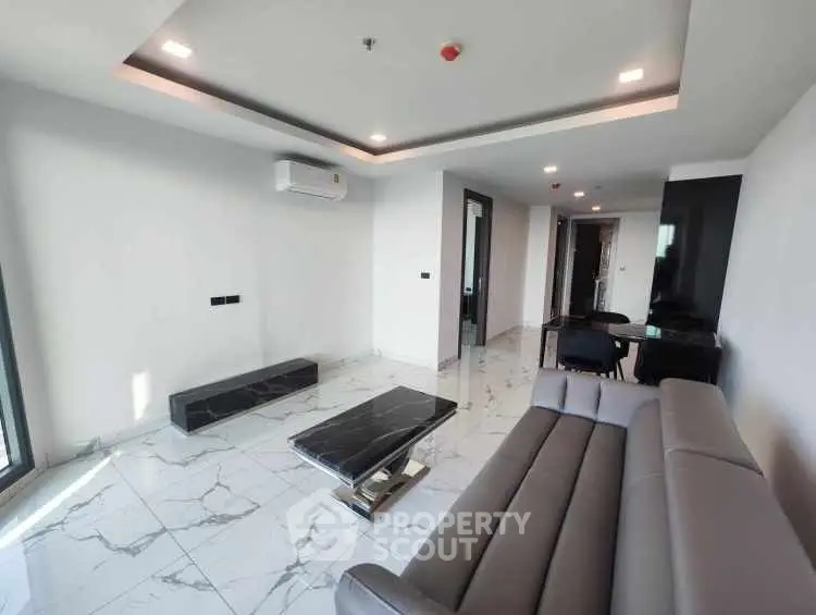Modern living room with sleek furniture and marble flooring in a contemporary apartment.