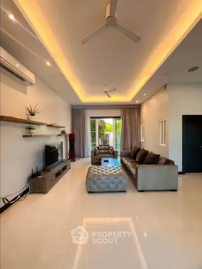 Spacious modern living room with elegant lighting and stylish furniture, perfect for relaxation and entertainment.