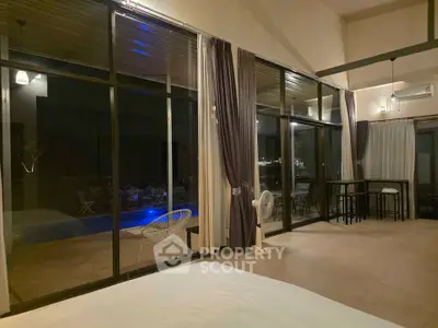 Spacious modern living room with floor-to-ceiling windows and pool view