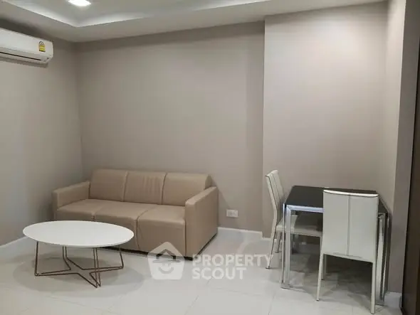 Modern living room with beige sofa and dining area in a stylish apartment.