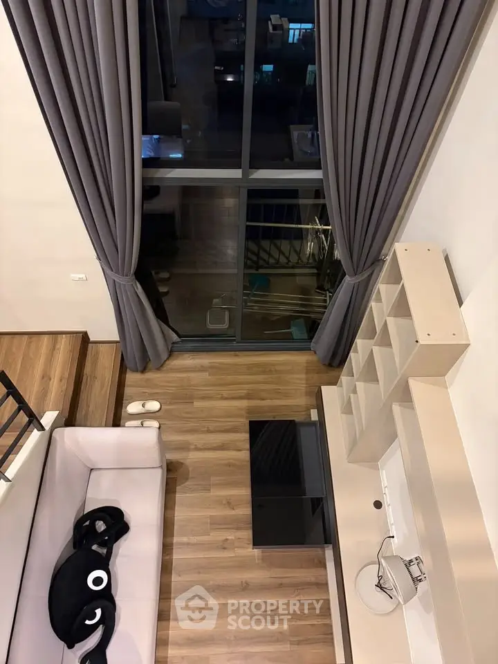 Modern living room with high ceiling and large window offering stunning views, featuring elegant decor and cozy seating.